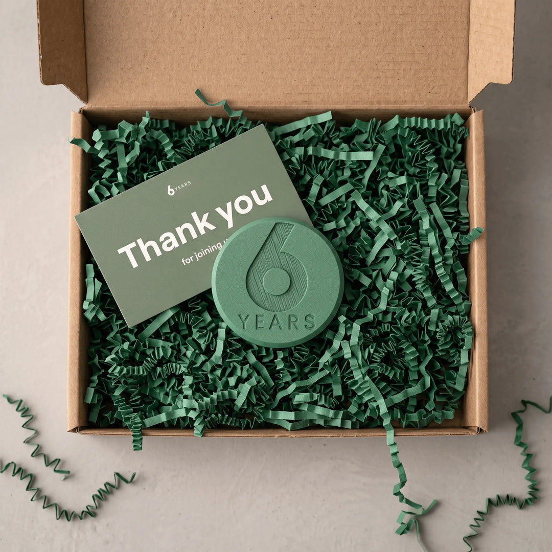 Offene Geschenkbox mit grünem Füllpapier und dem Key